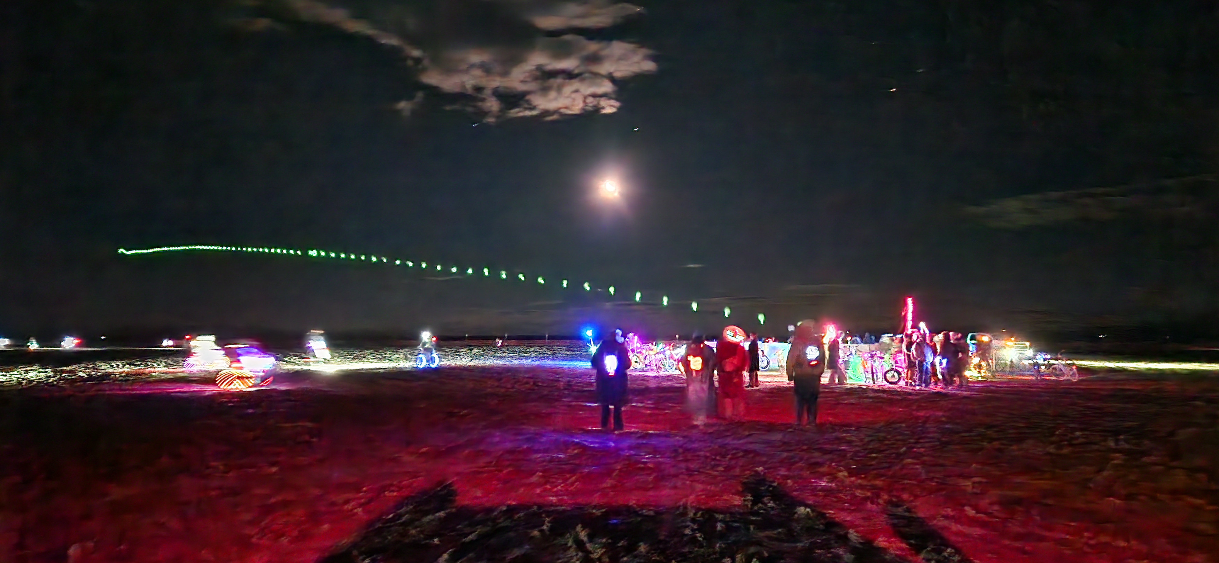 a circular sound installation in the desert at night with a chain of glowing balloons rising out of it