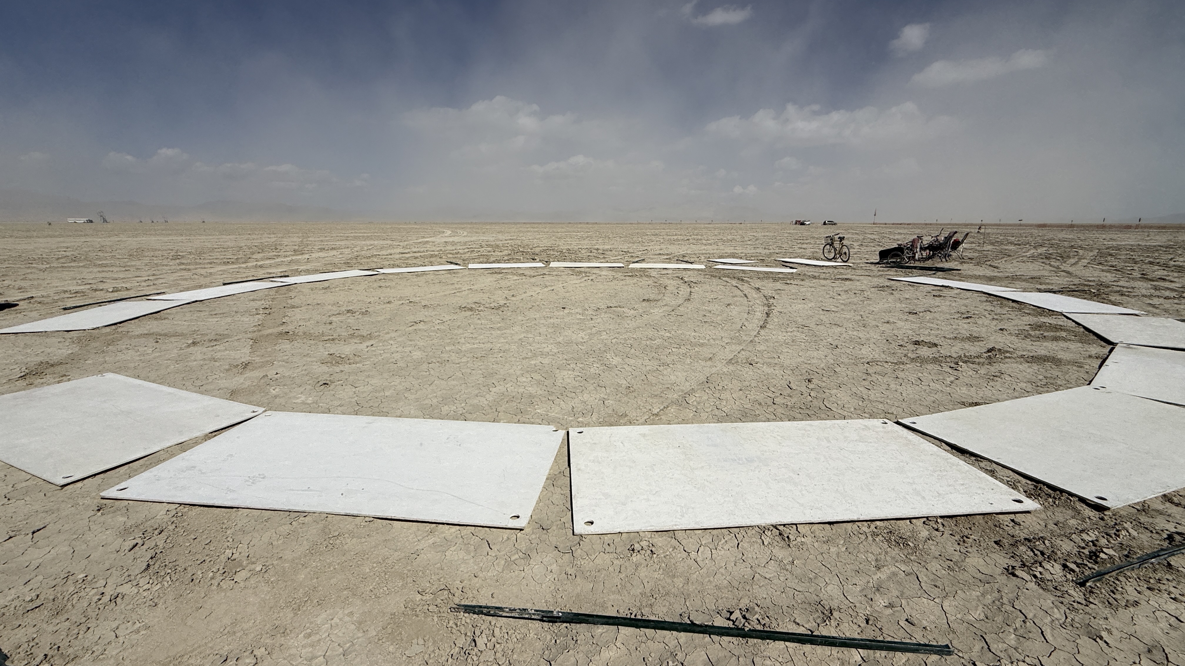 a circle of white rectanular wall segments lying flat on the ground, in the desert